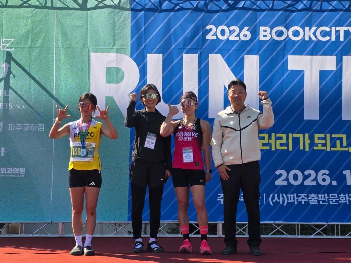 2026 파주북시티아트마라톤 10km 참가자들이 시상 무대에서 파이팅 포즈를 취하며 기념촬영을 하고 있다 하효종 기자 출처 파주신문 wwwpajunewscokr